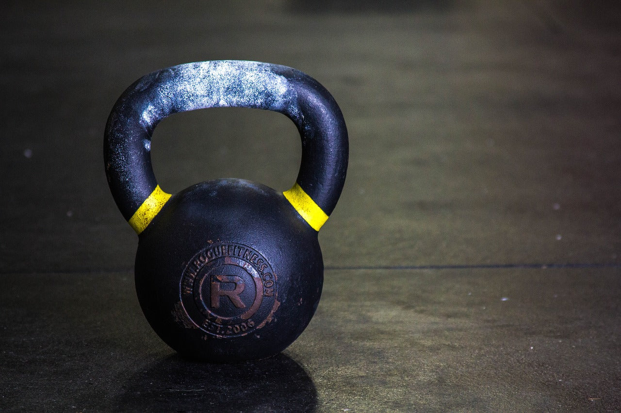 Kettlebell sur le sol démontrant une poignée avec de la craie.