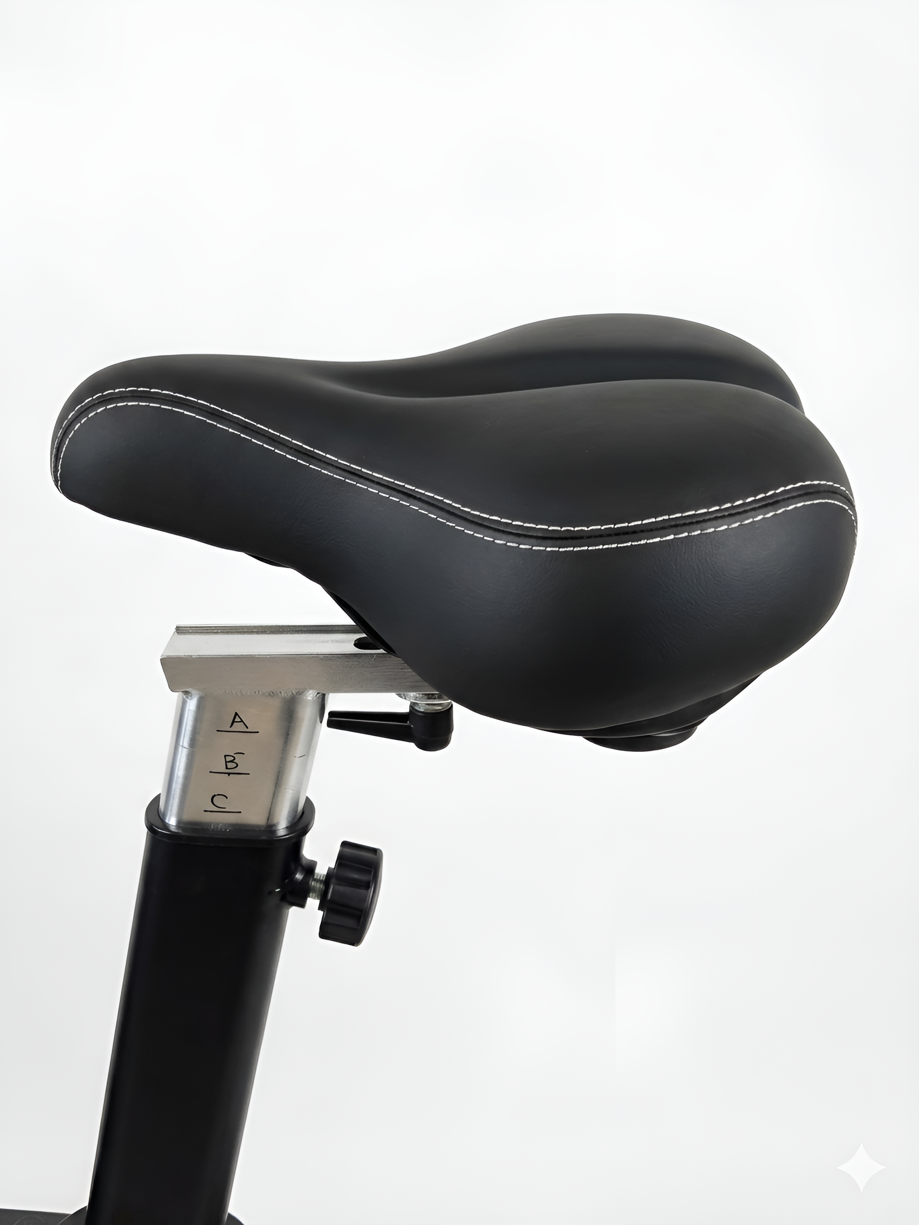 Un gros plan sur la selle de l'Airbike HALT3R Fitness. La selle est large, ergonomique et rembourrée pour un confort optimal, même lors d'entraînements prolongés. Le mécanisme de réglage en hauteur et en profondeur est visible.