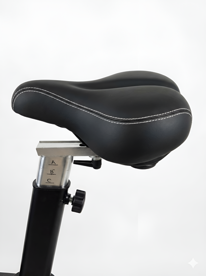 Un gros plan sur la selle de l'Airbike HALT3R Fitness. La selle est large, ergonomique et rembourrée pour un confort optimal, même lors d'entraînements prolongés. Le mécanisme de réglage en hauteur et en profondeur est visible.