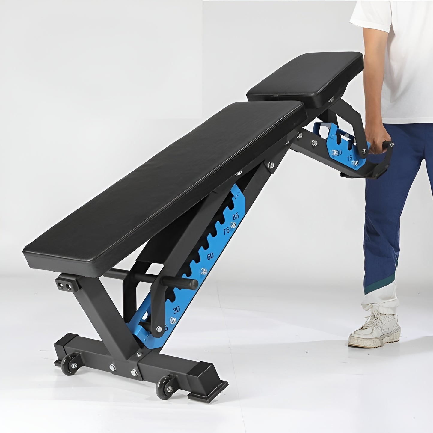 Utilisateur déplaçant facilement le banc de musculation lourd grâce aux roues de transport intégrées et à la poignée ergonomique.