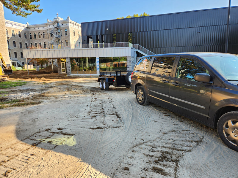 Camion et remorque de HALT3R Fitness sur le terrain de développement d'un projet de gym commercial au Collège Notre-Dame de l'Assomption.