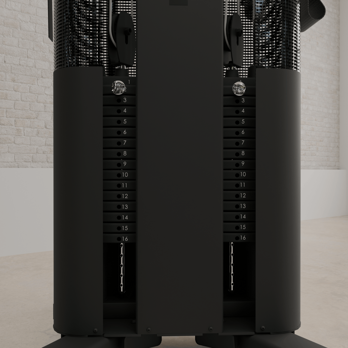 Vue détaillée des doubles piles de poids de 165 lb de la station d'entraînement Inspire FT1 PRO. Chaque pile est numérotée de 1 à 16, avec des plaques noires et une goupille de sélection chromée. Les colonnes sont protégées par des grillages métalliques. Mur de briques blanches en arrière-plan.