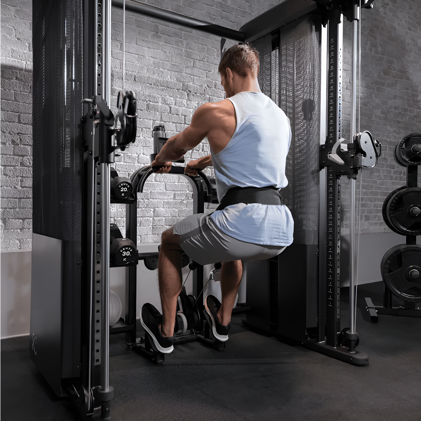 Homme effectuant un exercice de jambes avec les câbles ajustables de l'Inspire FT2 Pro.