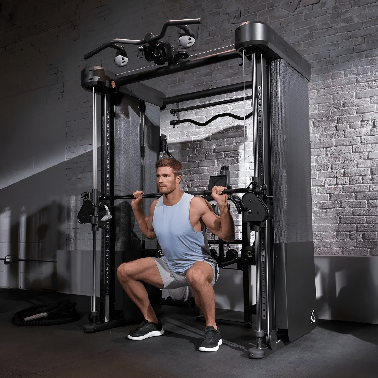 Homme utilisant l'appareil Inspire FT2 Pro pour un entraînement complet dans un home gym haut de gamme.