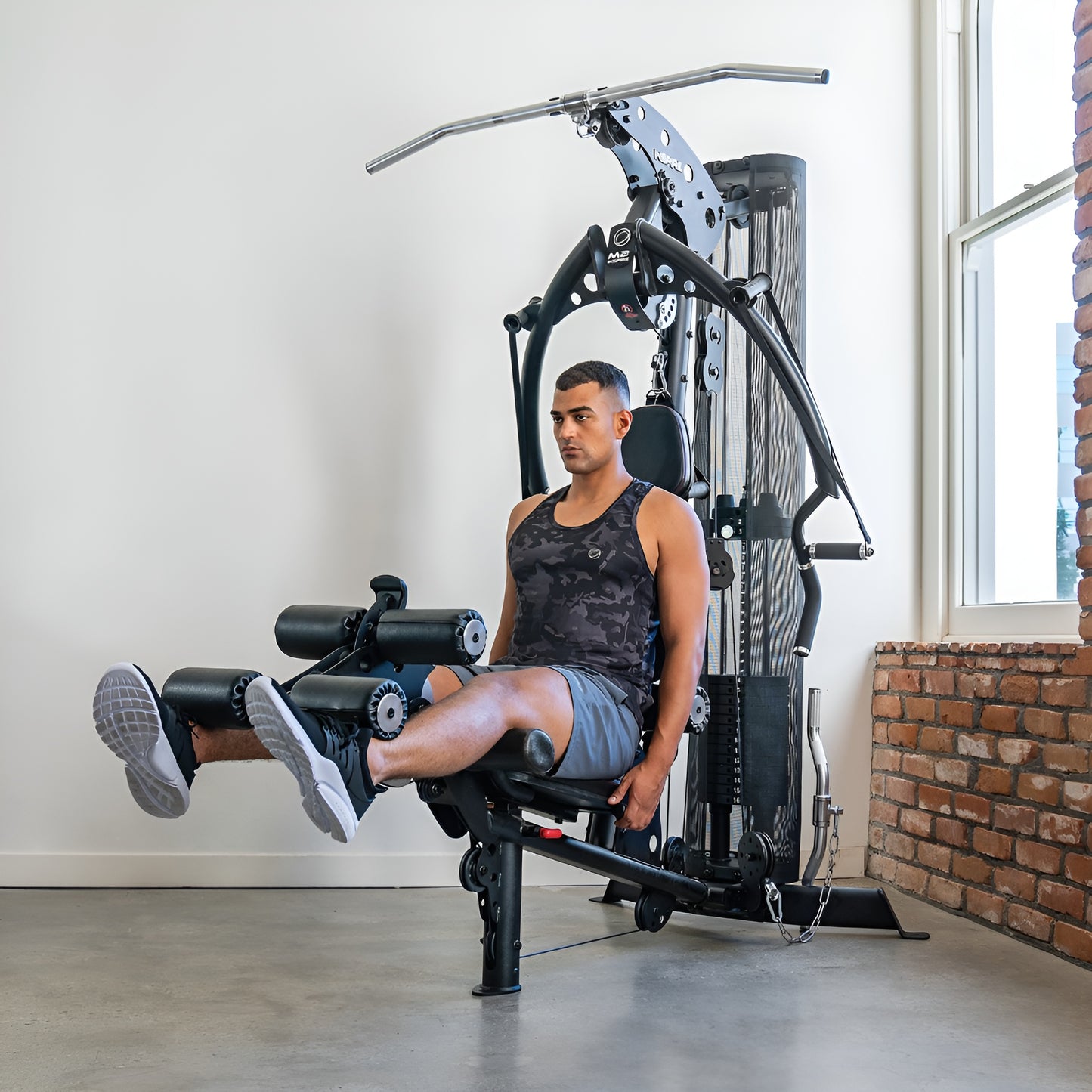 Mise en situation de la multi-station Inspire M2 dans un environnement de gym à domicile moderne et compact.