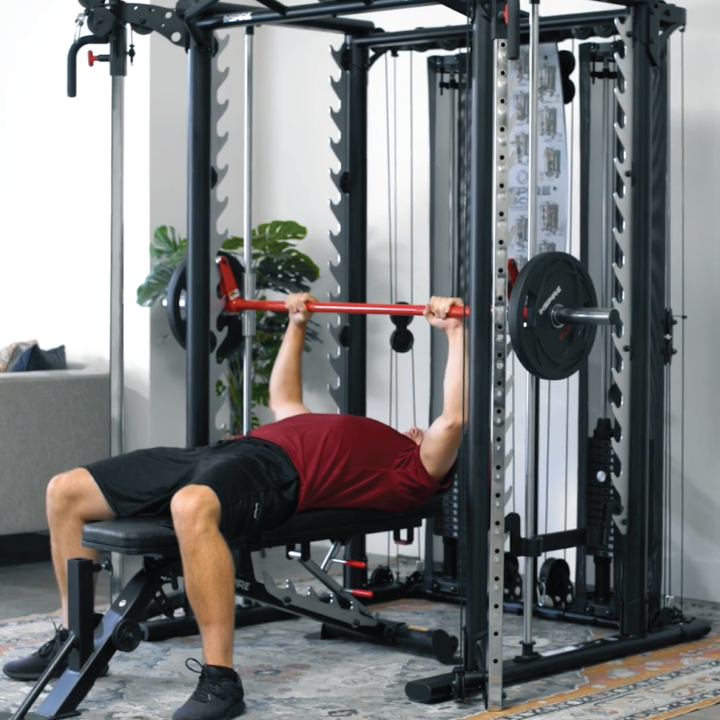 Athlète masculin utilisant les poulies ajustables de l'Inspire SCS pour un exercice de tirage dans un gym professionnel.