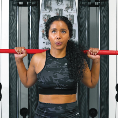 Configuration de la cage Inspire SCS pour les squats, montrant les supports de sécurité et la barre olympique.