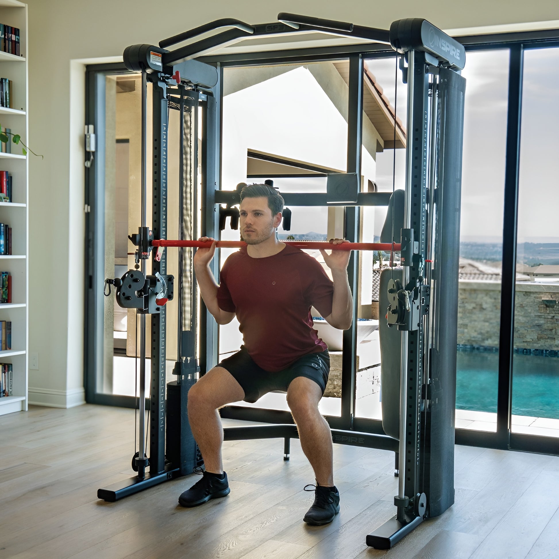 Exercice de squat effectué en toute sécurité avec la barre Smith guidée et sélectorisée du Inspire SF3.