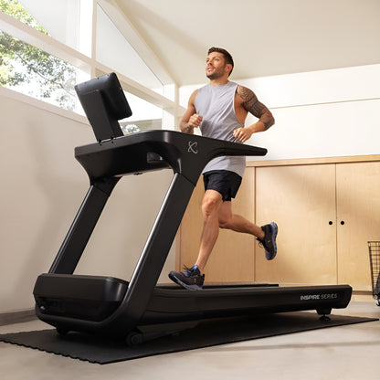 Utilisation du tapis roulant Inspire T7S dans un décor de gym à domicile (home gym) moderne et lumineux.