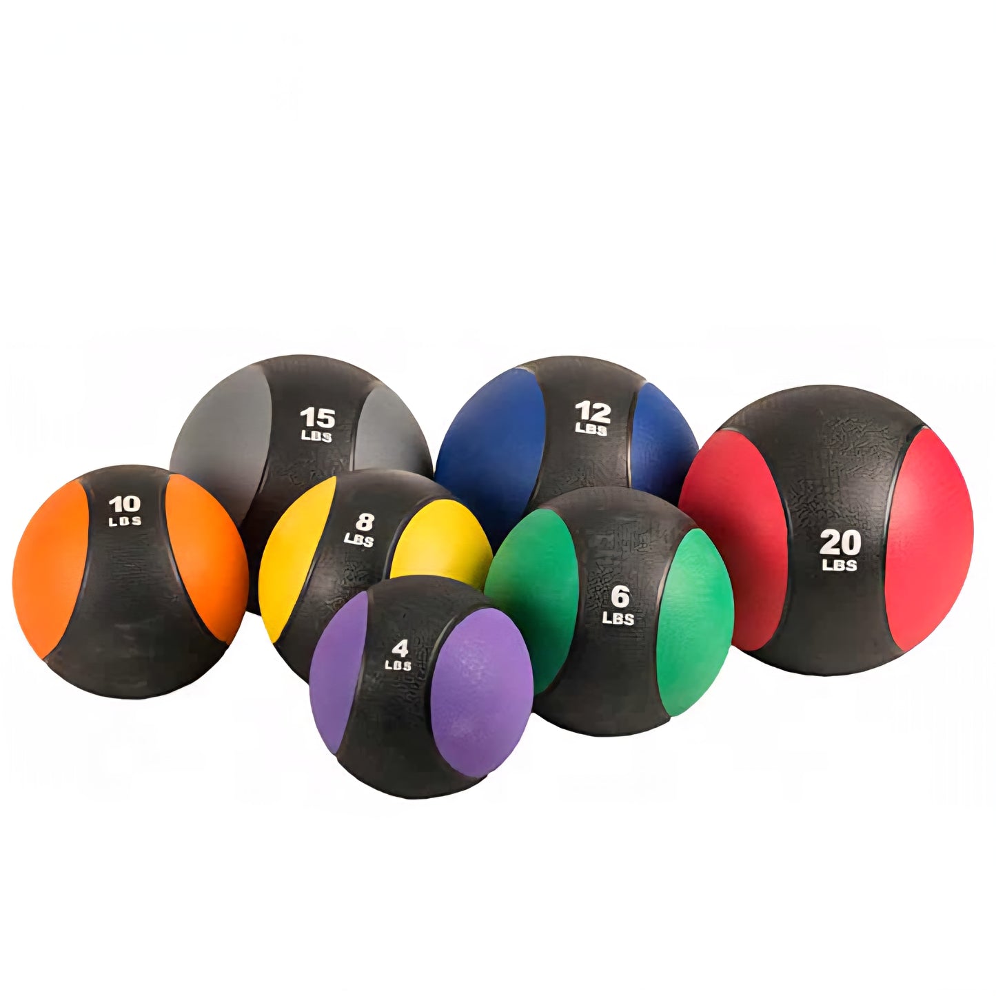 Ensemble de medicine balls de différentes tailles empilés sur le sol du gym — vue d'ensemble montrant textures et couleurs
